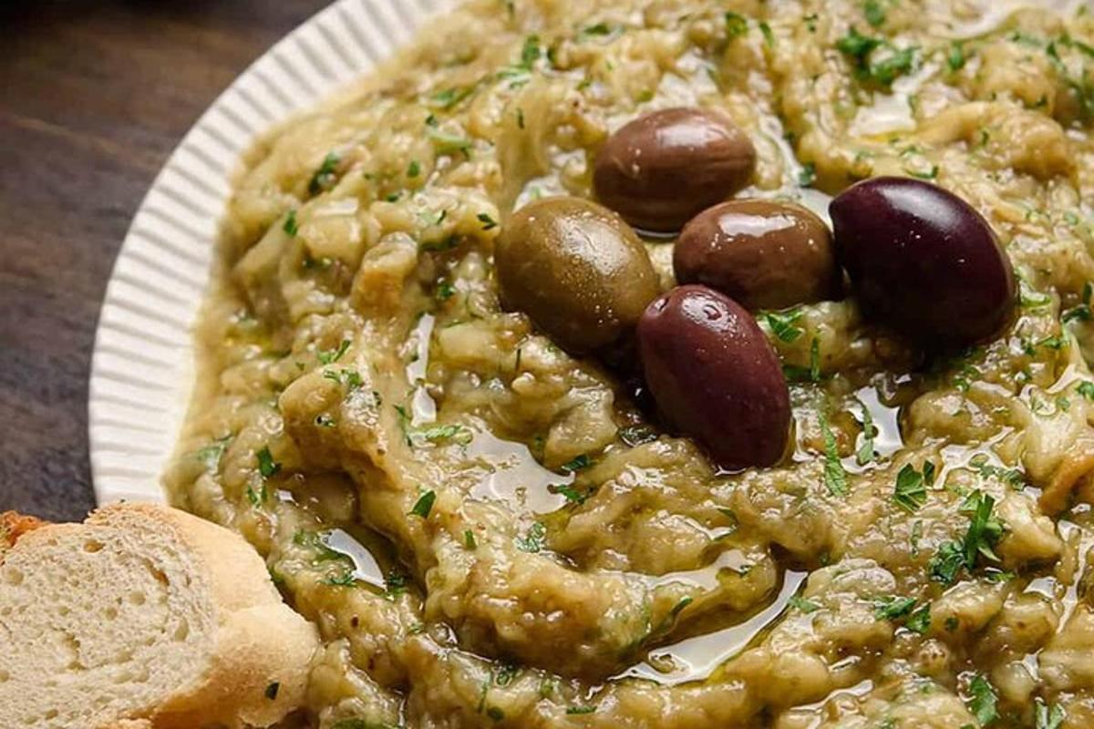 una pizza con fagioli e olive su un piatto di carta
