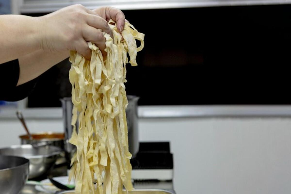 una persona che tiene in mano un mucchio di spaghetti