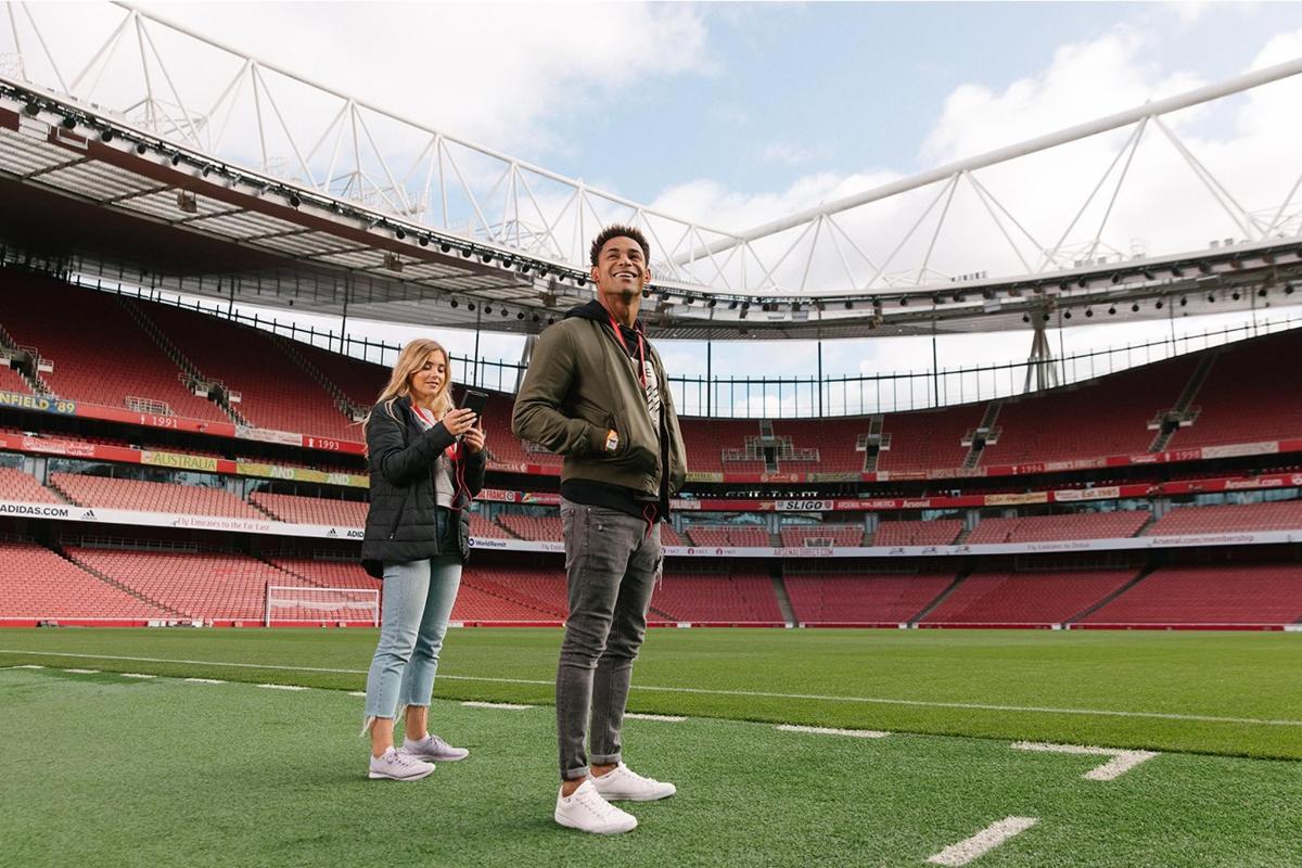 a man and woman standing on a soccer field at a stadium