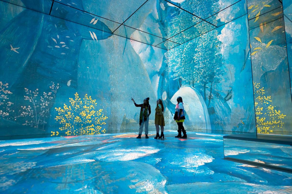 a group of people standing in front of a large aquarium