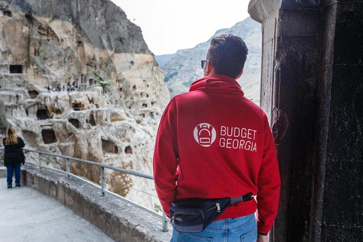 a man in a red sweatshirt looking at a mountain