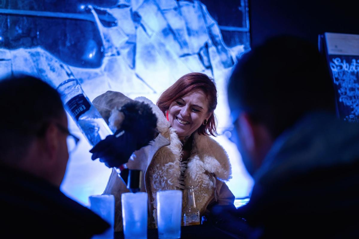 žena sedící u stolu a držící plyšáka