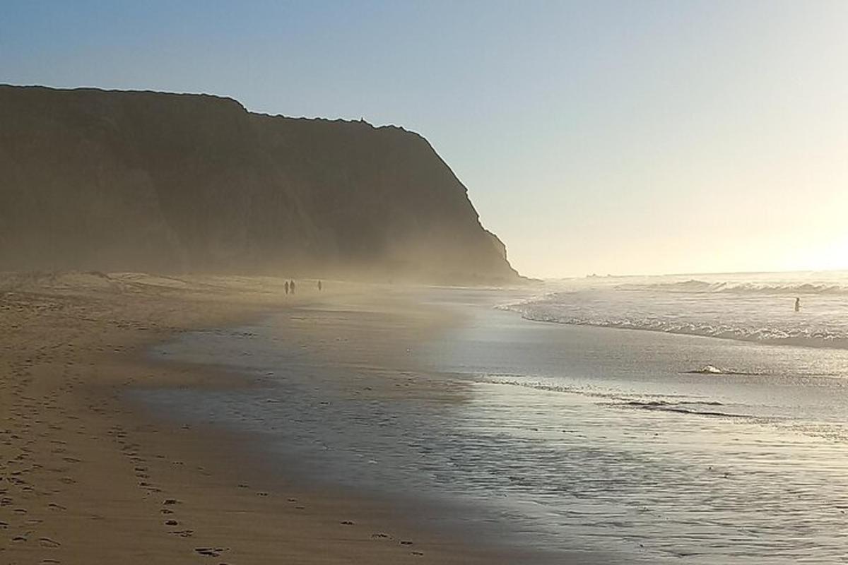 pantai dengan orang berjalan di atas pasir