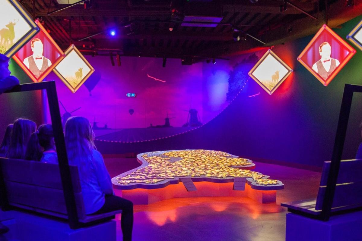 uma sala com uma mesa e um palco com pessoas