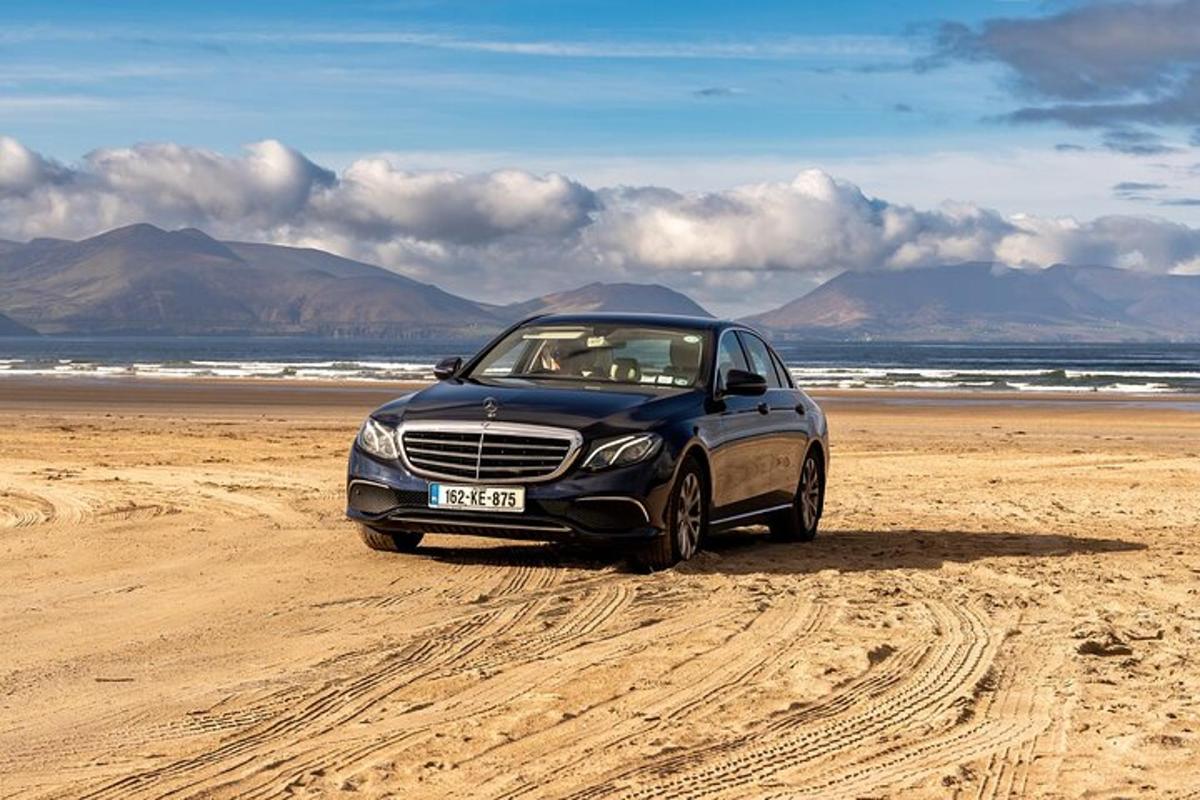 une voiture noire garée sur une plage de sable