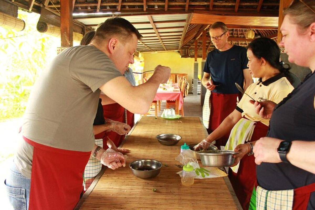 sekumpulan orang berdiri mengelilingi meja menyediakan makanan