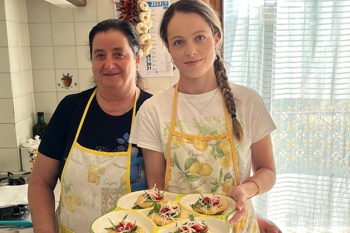 дві жінки стоять на кухні, тримаючи тарілку з їжею