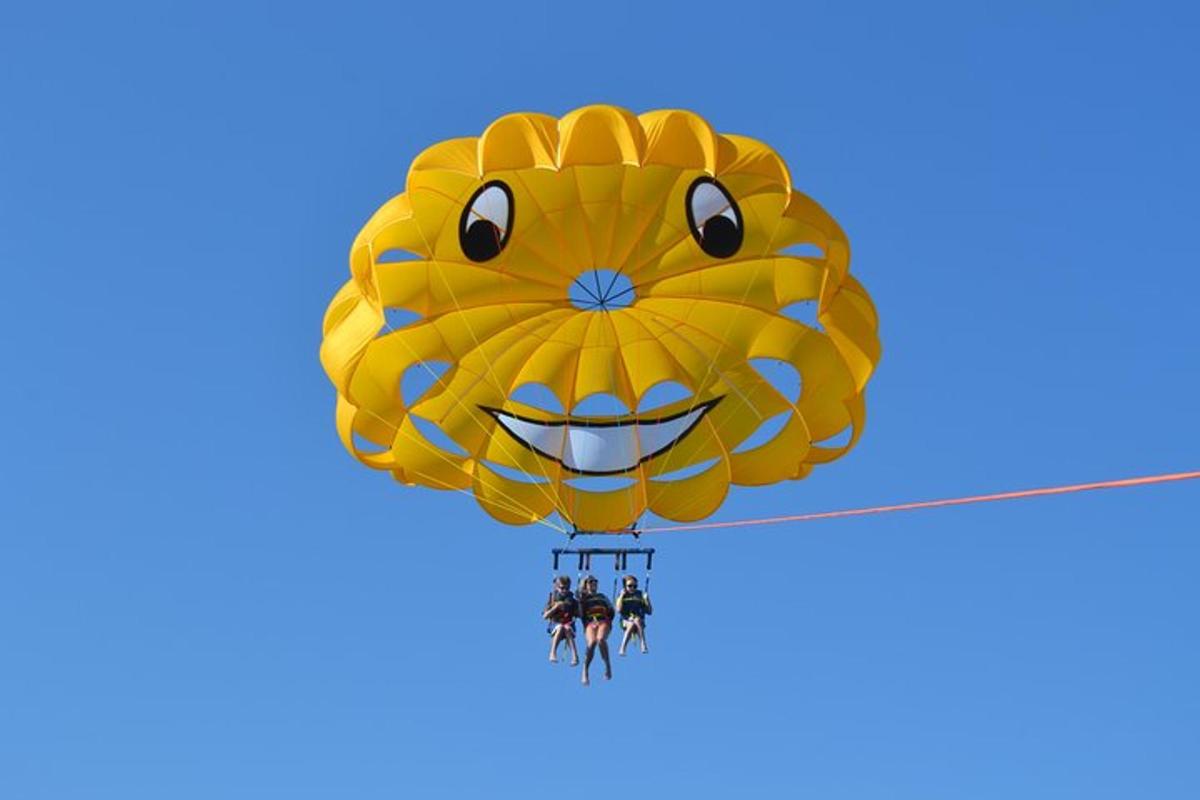a group of people hanging from a yellow parachute