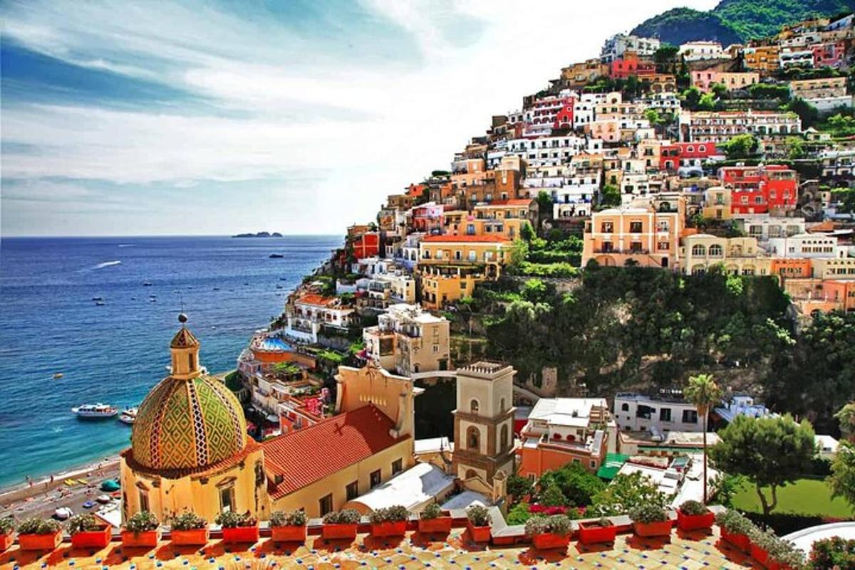 a view of a town on a hill next to the ocean