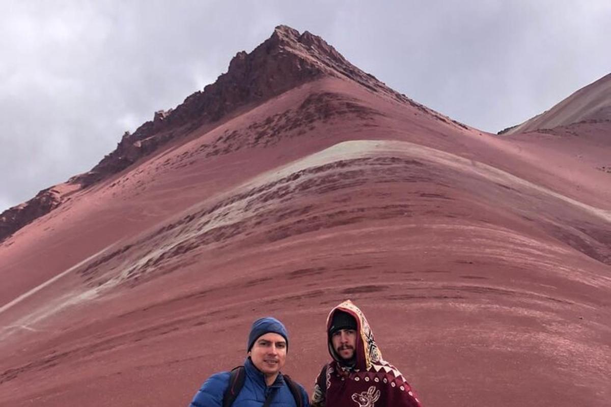 dua lelaki berdiri di hadapan bukit pasir merah