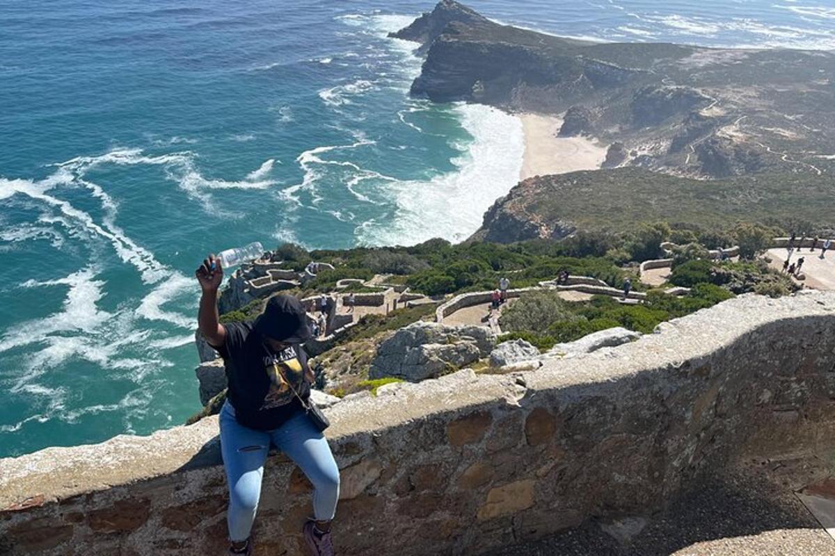 uma pessoa parada na beira de um penhasco com vista para o oceano