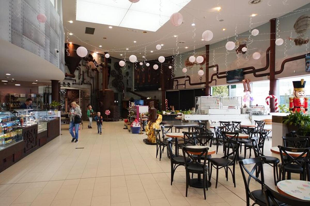 a restaurant with chairs and tables and people walking through it