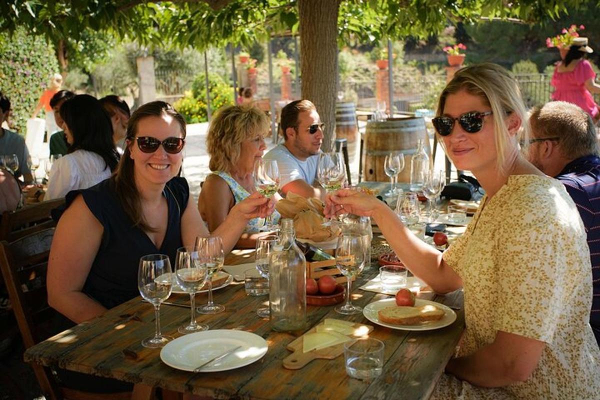 Un grupo de personas sentadas en una mesa con copas de vino.