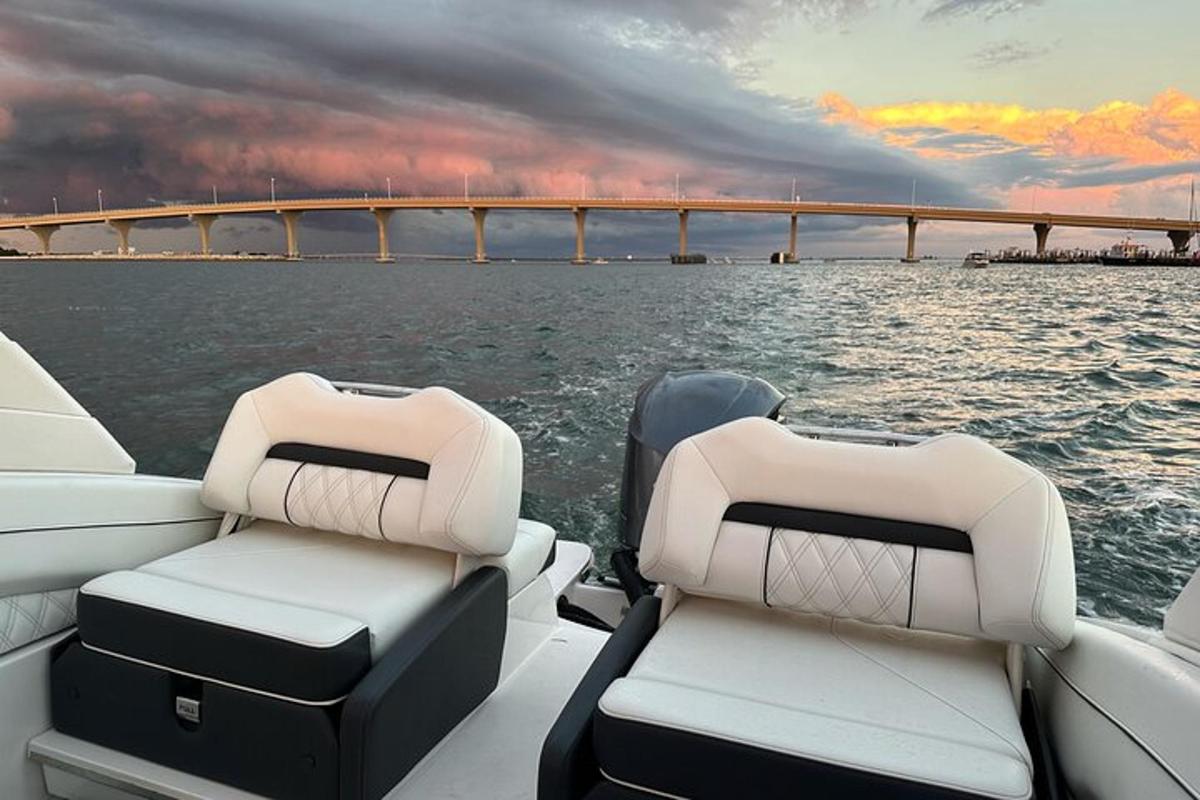 twee stoelen op een boot in het water met een brug