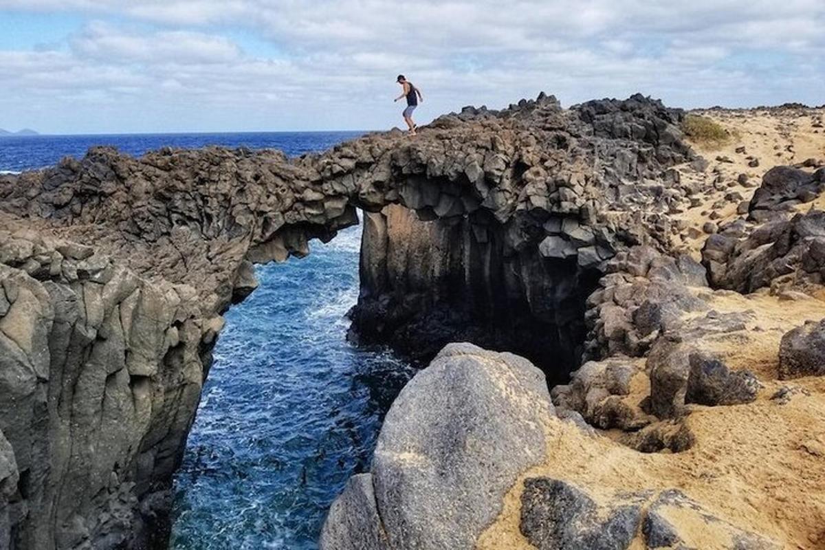a person standing on top of a cave in the ocean