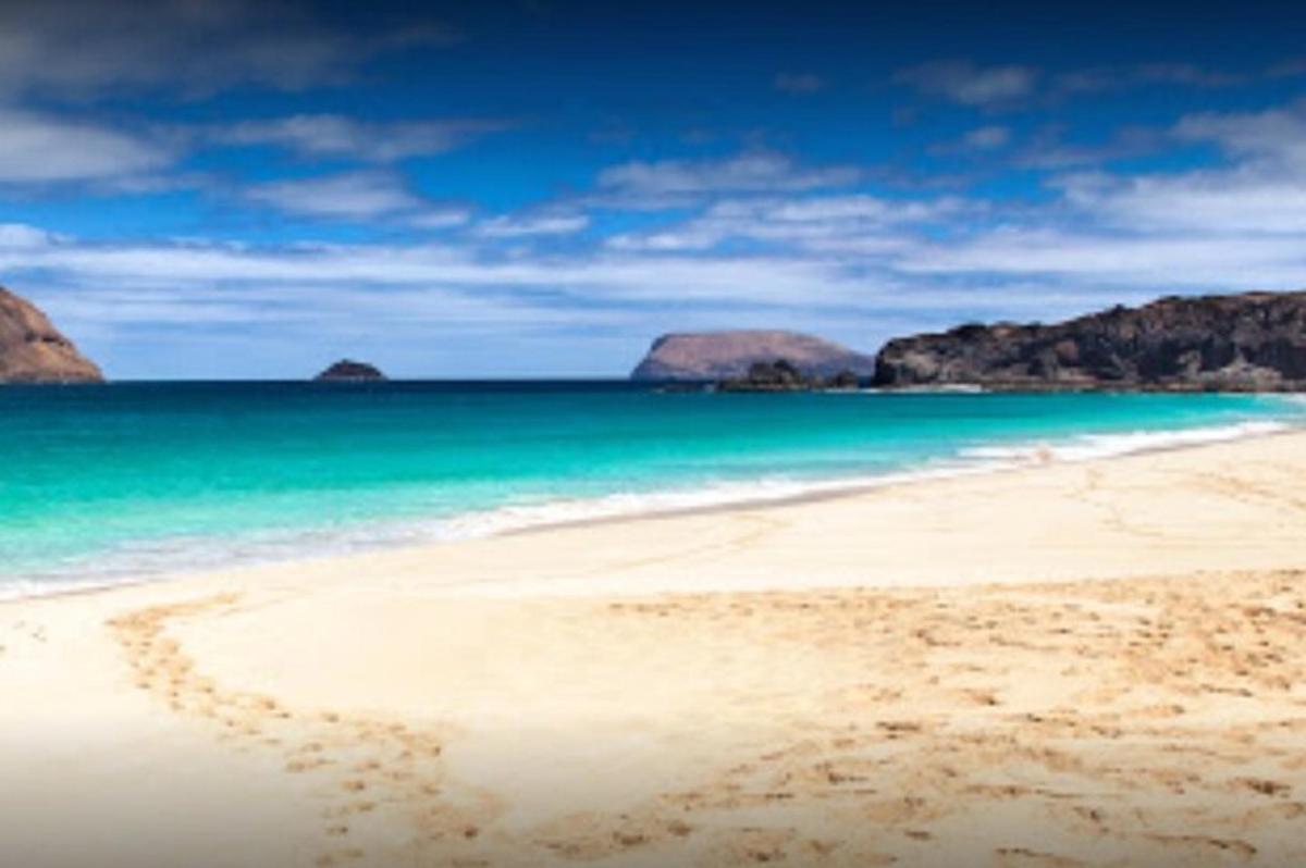 an empty beach with rocks in the water