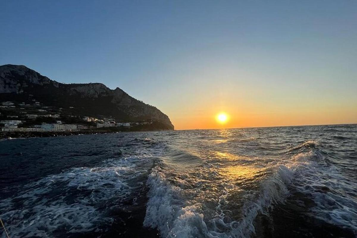 захід сонця з човна у воді