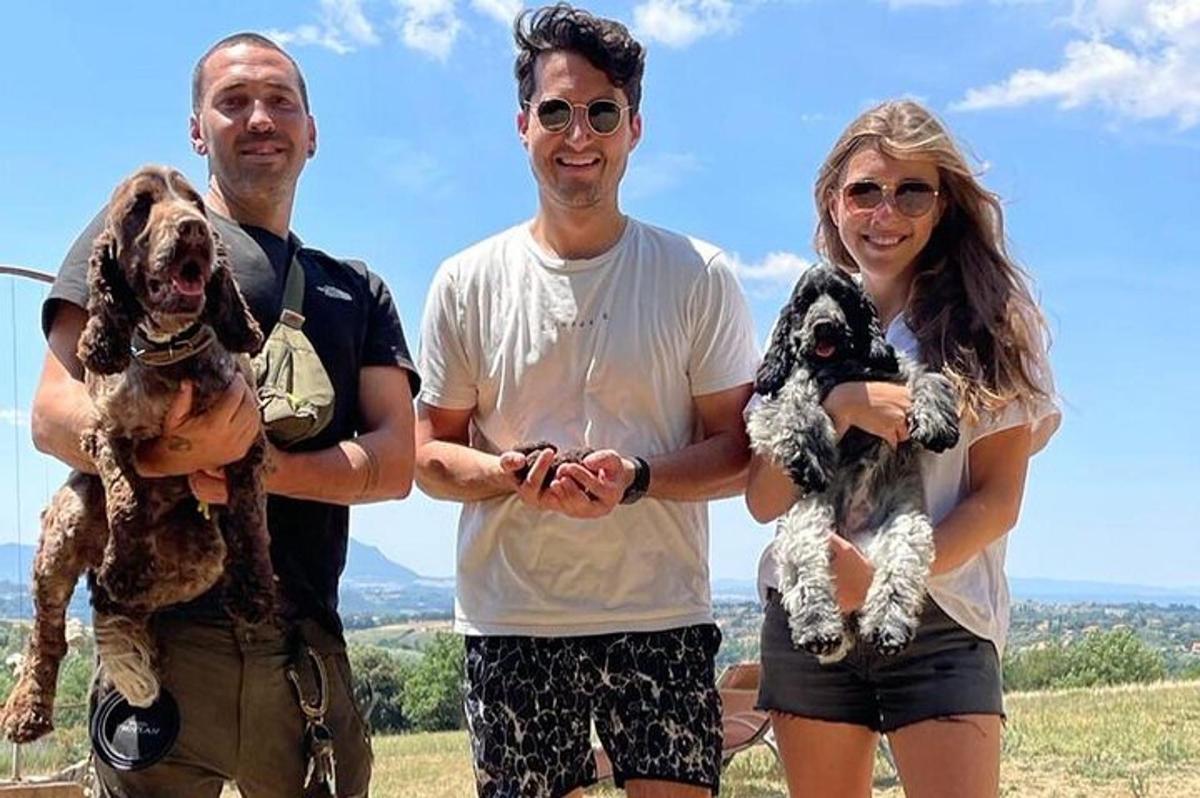 two men and a woman holding a dog
