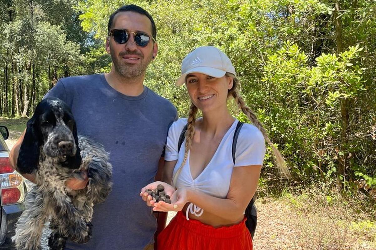 a man and a woman standing next to a dog