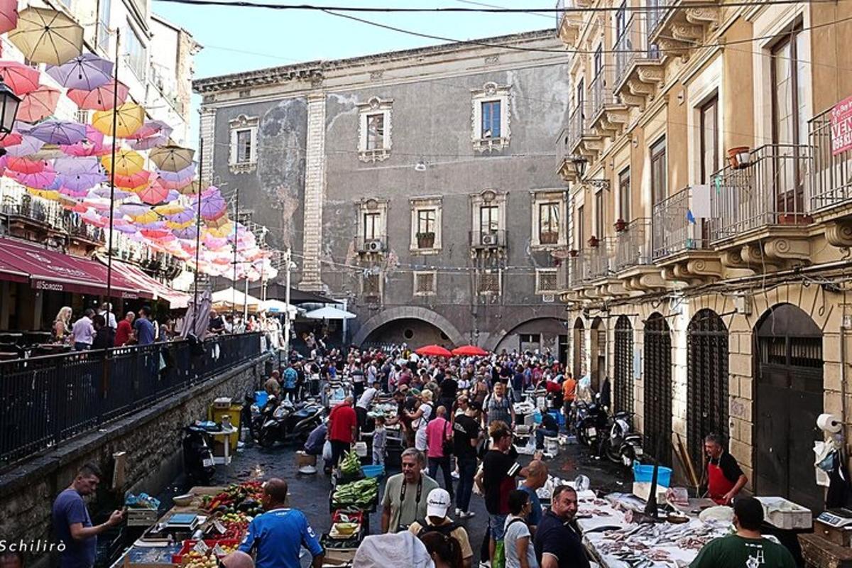 a crowd of people walking around an outdoor market