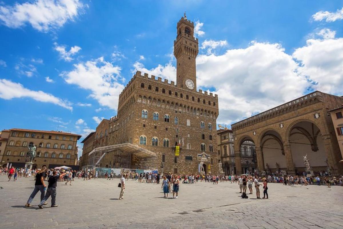 un gruppo di persone che camminano intorno a un edificio con una torre dell'orologio