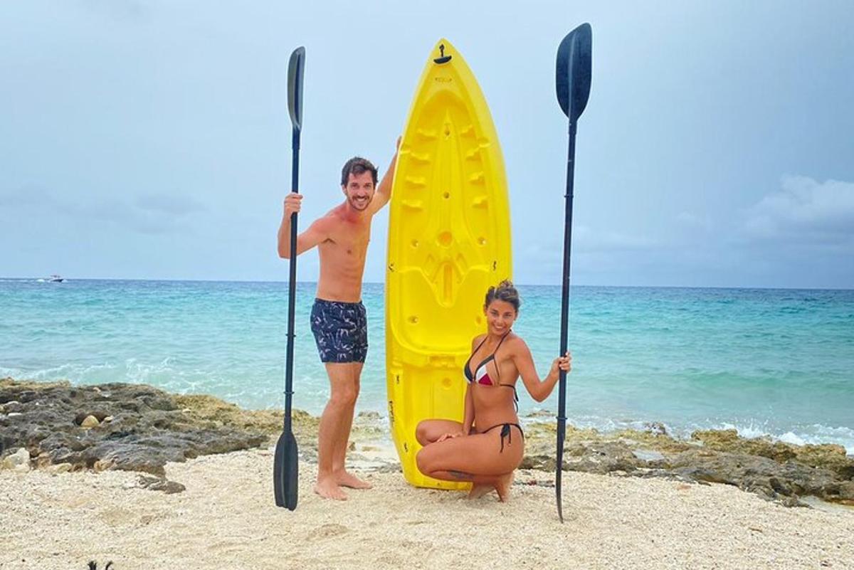 een man en een vrouw staan naast een geel surfplank