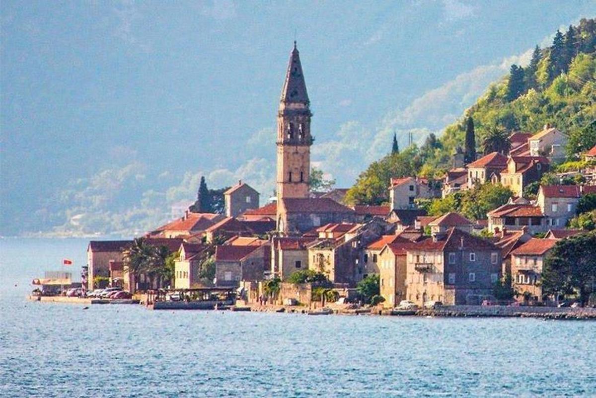 uma cidade na água com uma torre do relógio