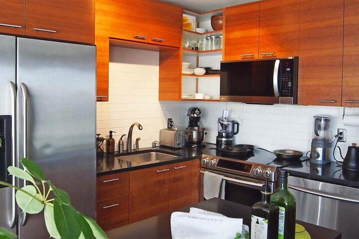 một nhà bếp với các thiết bị bằng thép không gỉ và tủ gỗ