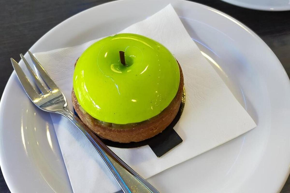 a green donut on a white plate with a fork
