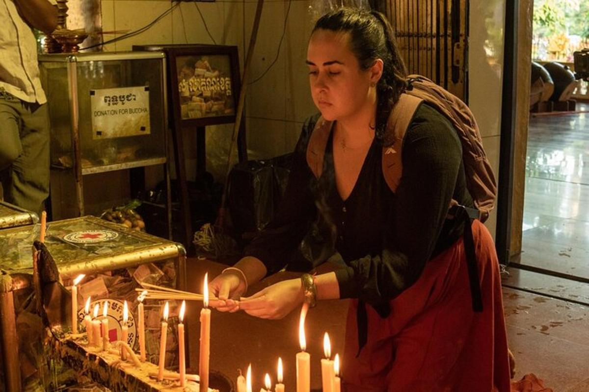 Una mujer está encendiendo velas en una habitación.