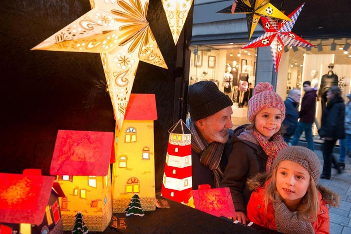 a man and two children looking at a display of gingerbread houses