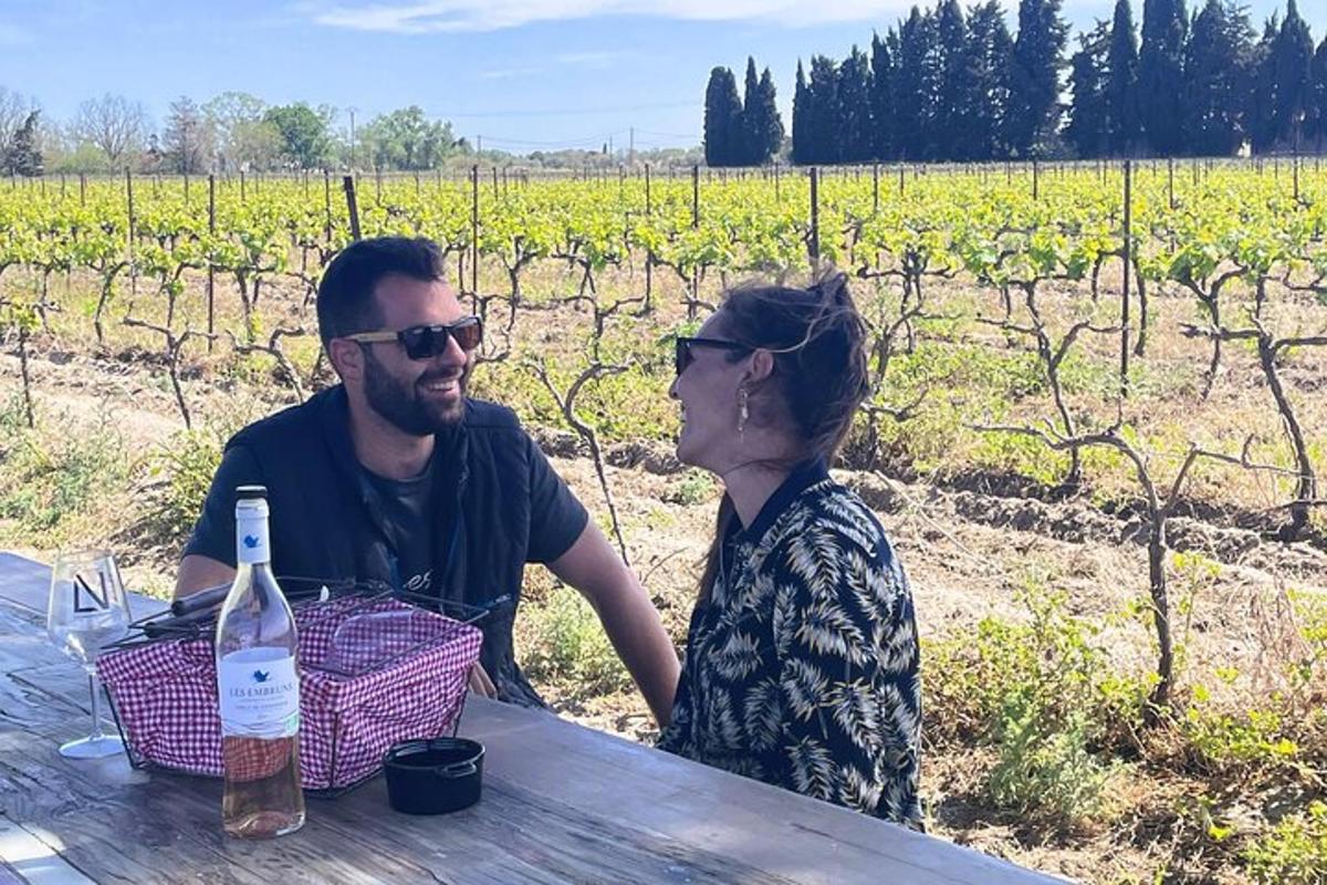 un bărbat și o femeie așezați la o masă cu o sticlă de vin
