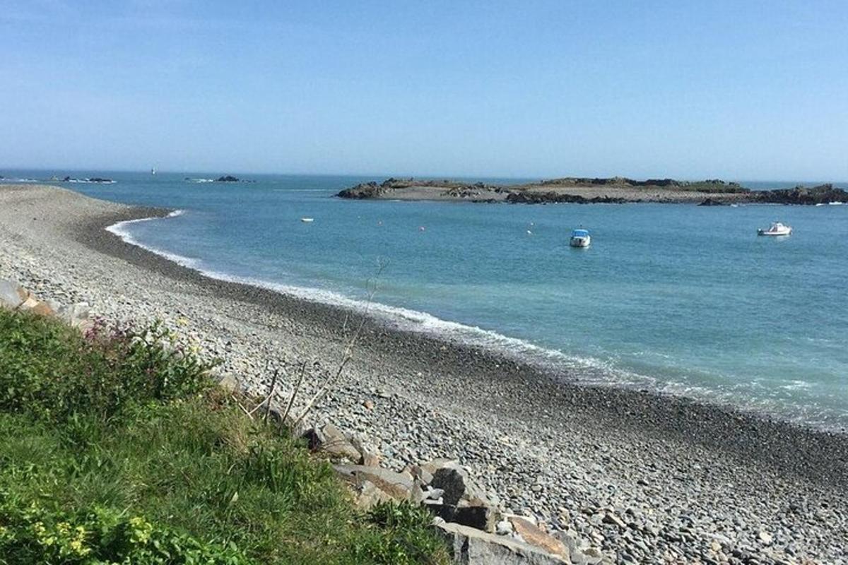 a rocky beach with two boats in the water