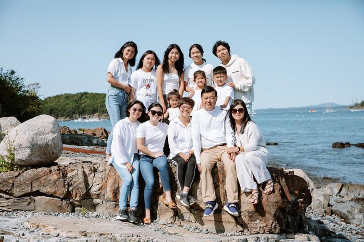 a group of people sitting on rocks on the beach