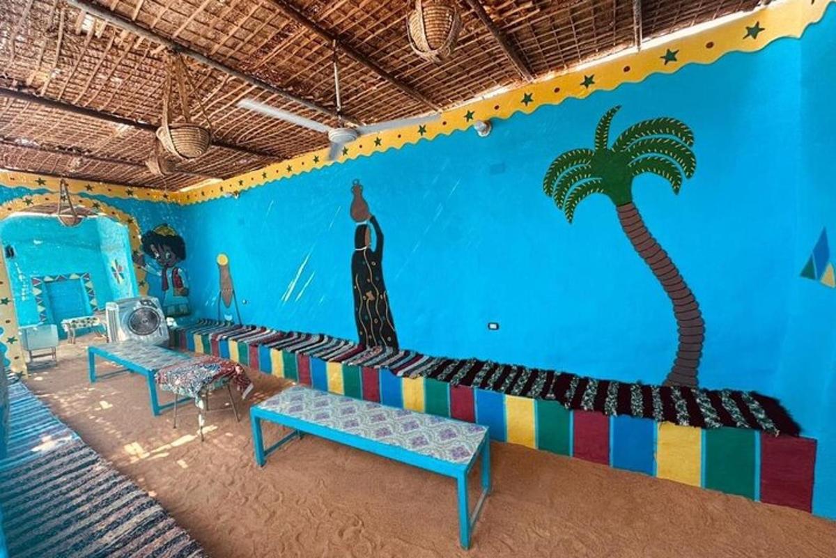 una habitació amb un sofà amb una palmera pintada a la paret