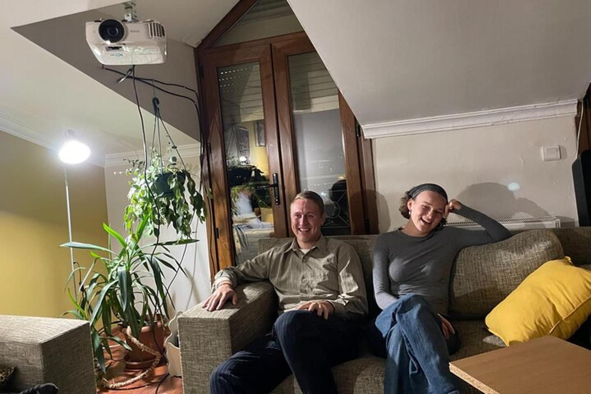 dois homens sentados em um sofá em uma sala de estar
