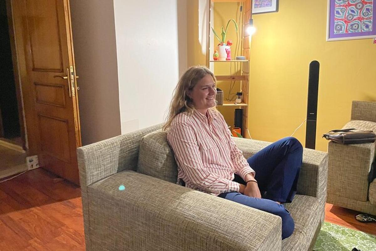 uma mulher sentada em um sofá em uma sala de estar