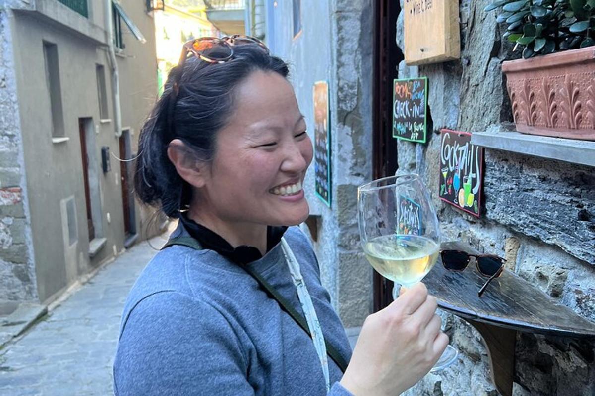 una mujer sosteniendo una copa de vino blanco