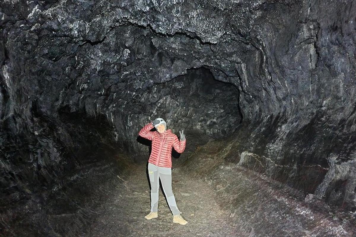 nainen seisoo pimeässä luolassa