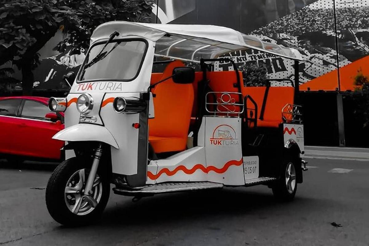 isang maliit na puting golf cart na may kulay kahel na upuan