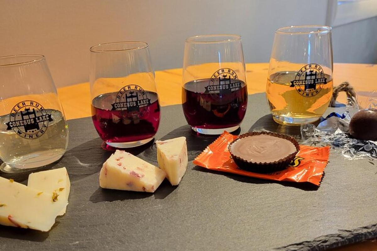 a table with four glasses of wine and cheese