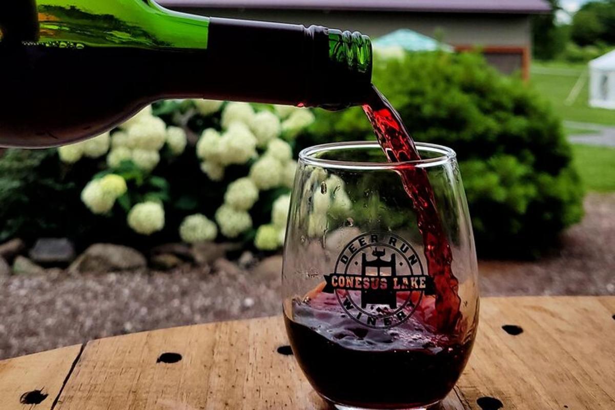a person pouring red wine into a glass
