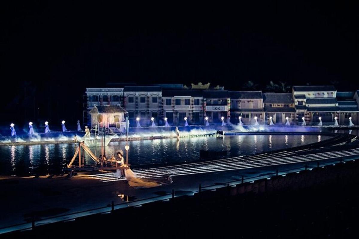 a large building with lights on the water at night