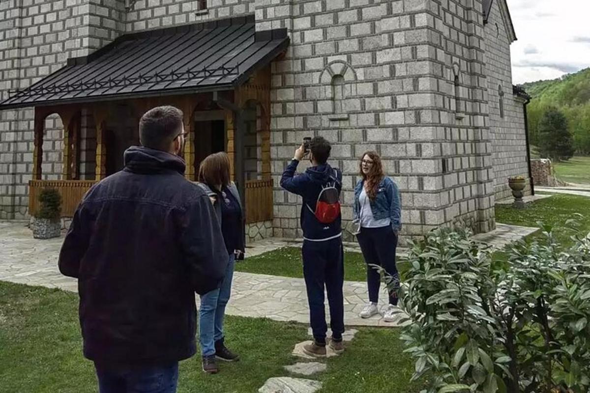 skupina lidí stojících před cihlovou budovou
