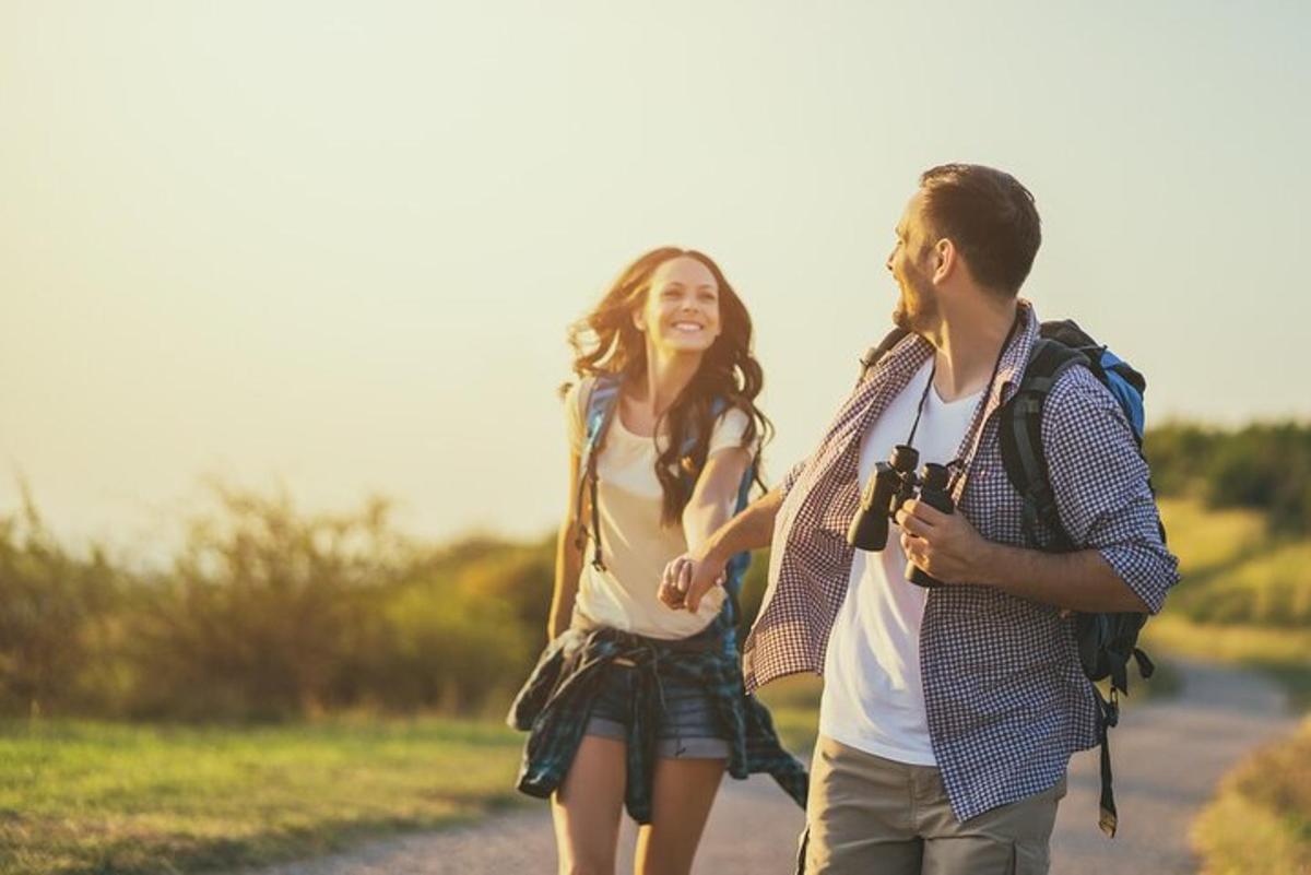 a man and a woman walking down a road with a camera