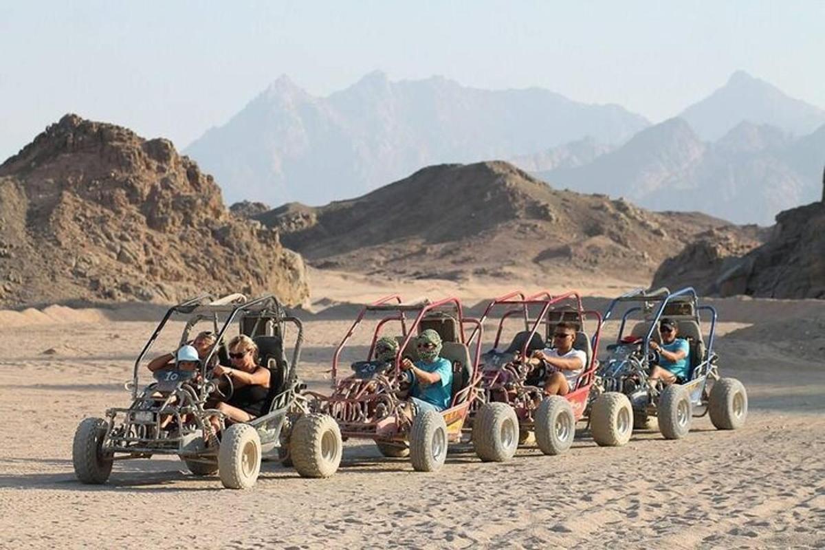 um grupo de pessoas andando de quadriciclo no deserto