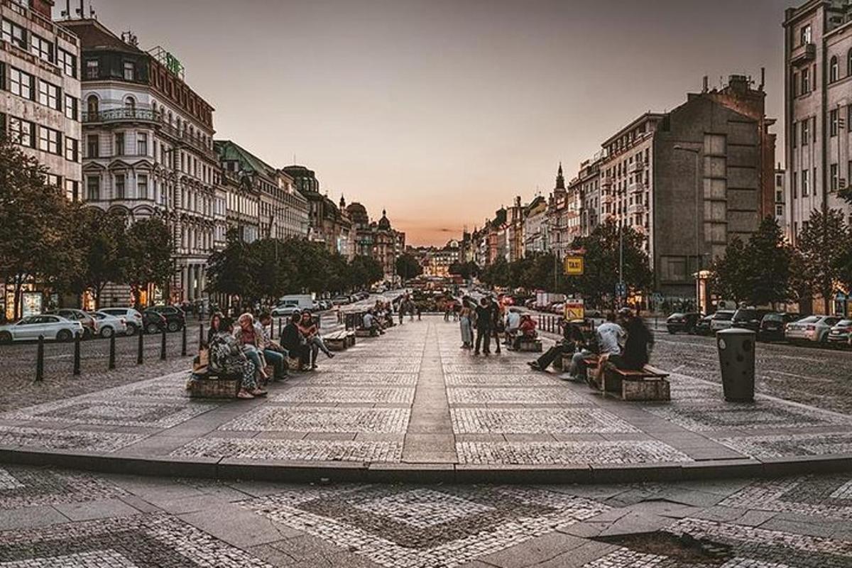 hópur fólks situr á bekkjum á götu í borginni
