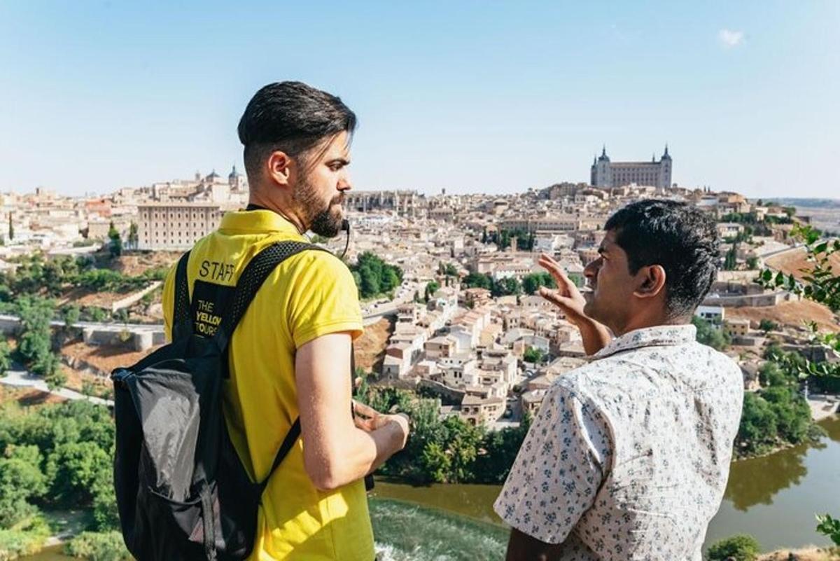 Dos hombres de pie en la cima de una colina mirando una ciudad