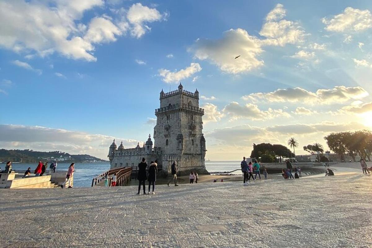 skupina ljudi, ki stojijo okoli stolpa na plaži