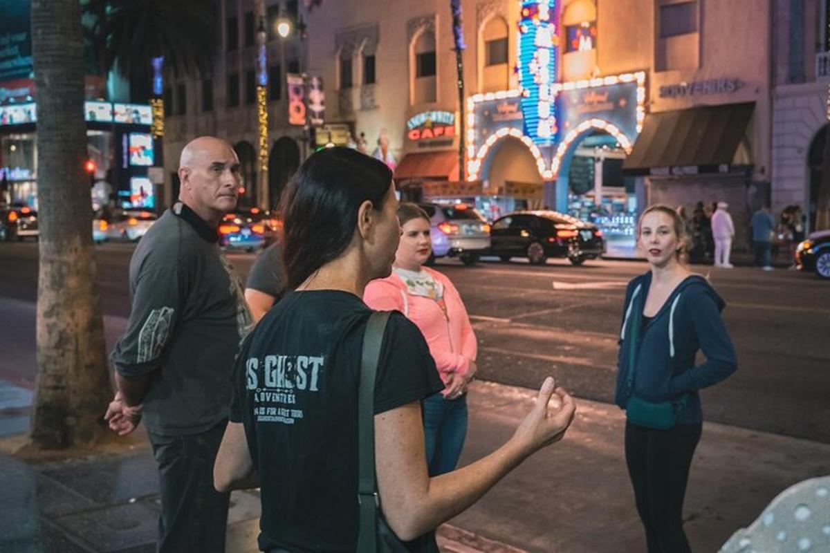 a group of people standing on a city street at night